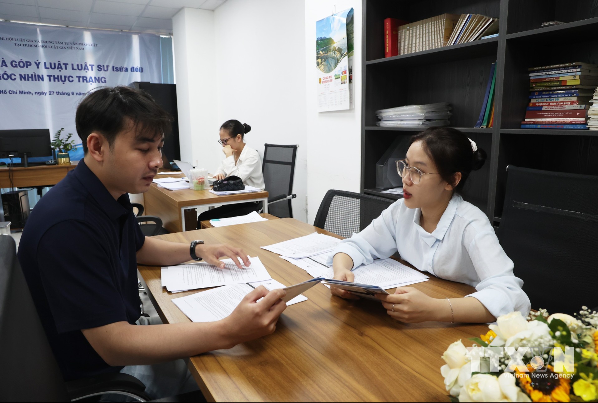 Nhân viên Trung tâm Tư vấn phát luật tại TP. Hồ Chí Minh tư vấn pháp luật trao đổi, tư vấn hồ sơ cho người dân. (Ảnh: Hồng Đạt/TTXVN)